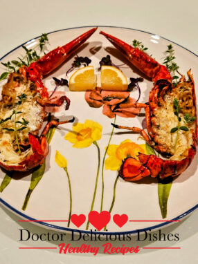 Grilled whole lobster cut in half and served on a decorative floral plate.