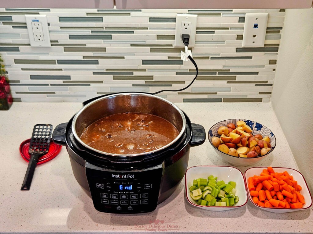 Prepared vegetables—potatoes, carrots, celery—ready to be added to the beef stew mixture in the Instant Pot.