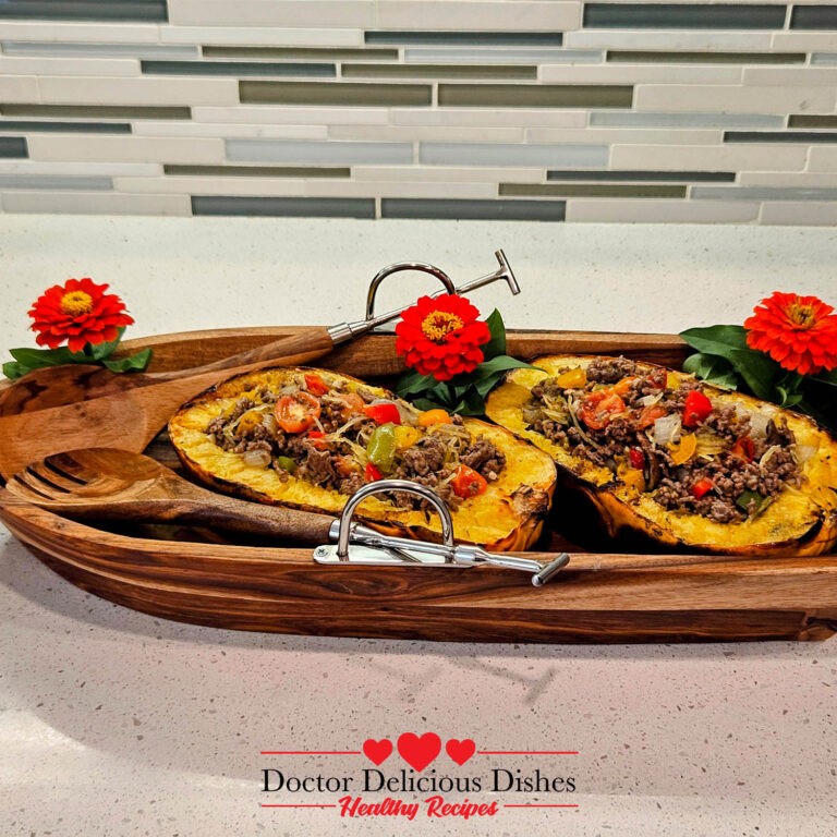 The final dish, two roasted spaghetti squash halves filled with the ground beef mixture, presented in a rustic wooden serving bowl, garnished with vibrant red flowers, giving a fresh, colorful presentation of the dish.