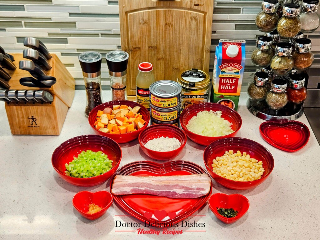 Ingredients for the Best Classic New England Clam Chowder Recipe with a Twist neatly displayed in red bowls, including fresh vegetables, bacon, and clam juice, on a clean countertop.