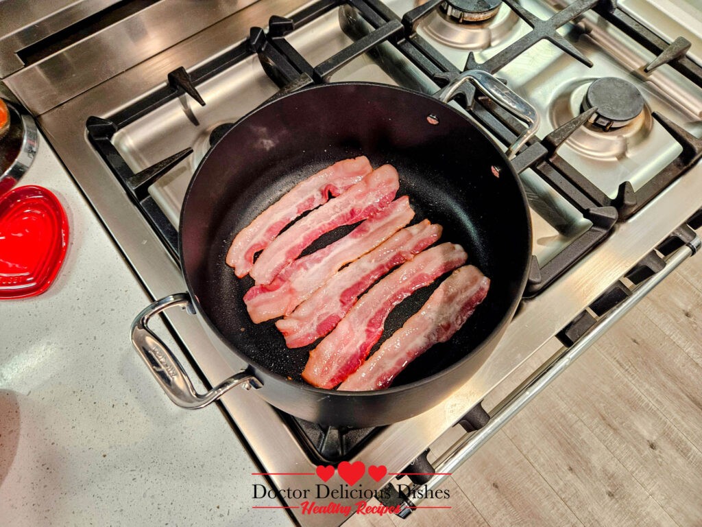 Bacon cooking in a pot for the Best Classic New England Clam Chowder Recipe with a Twist on a modern gas stovetop.