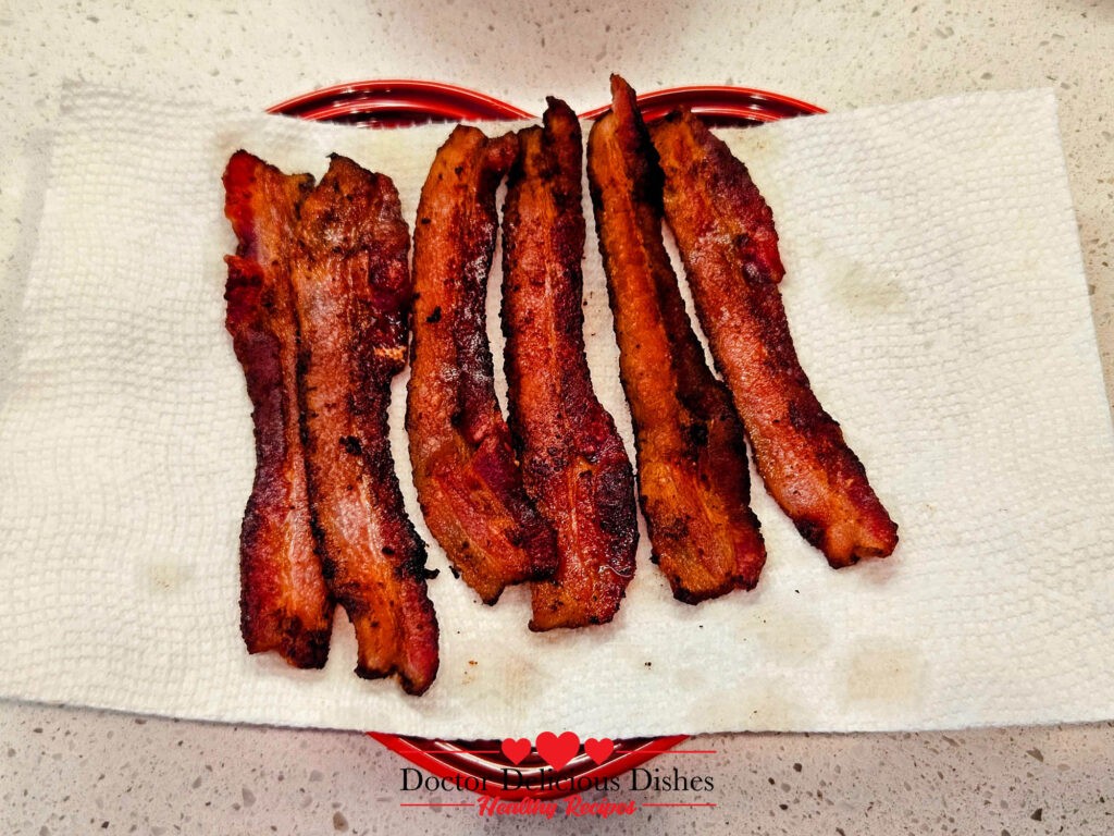 Crispy bacon slices for the Best Classic New England Clam Chowder Recipe with a Twist, freshly cooked and draining on paper towels.