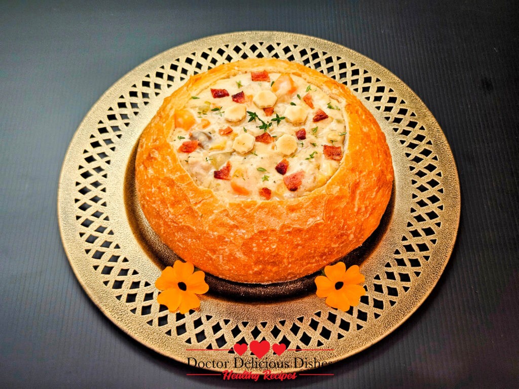 A rustic bread bowl filled with rich clam chowder, garnished with bacon and fresh thyme, presented on a dark background with flower garnish.