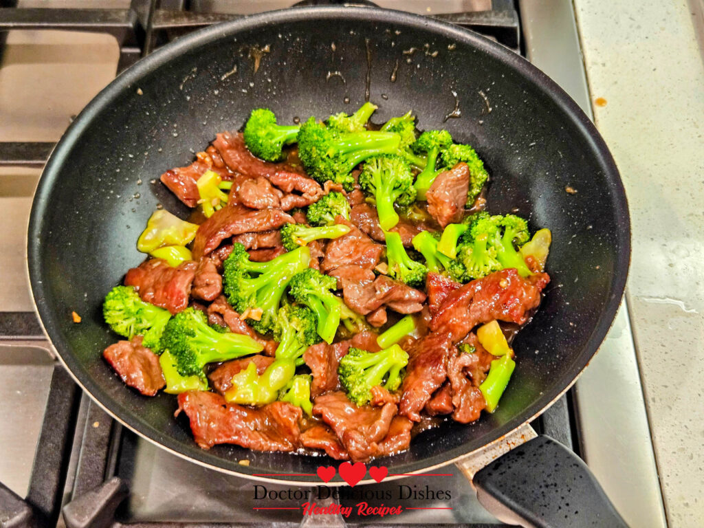 Beef and broccoli stir-fried together in a skillet for Chinese Beef and Broccoli Recipe.