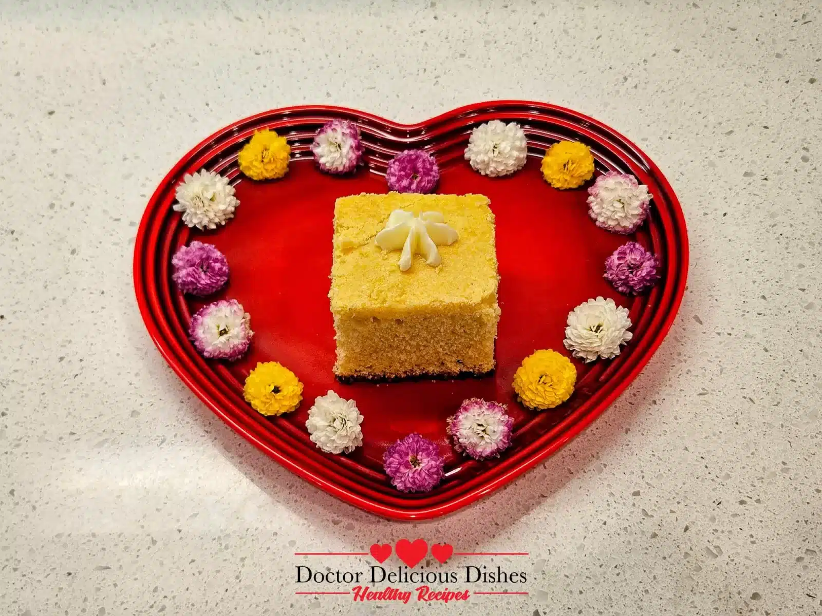 Serving the homemade cornbread on a heart shaped plate with a flower shaped dollop of butter melting on top and several flowers decorating the edge of the plate.