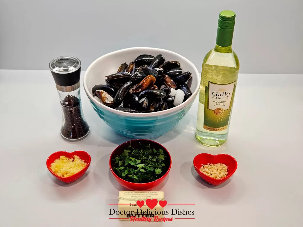 An arrangement of mussels and ingredients: butter, lemon zest, chopped parsley, minced garlic, white wine, and black pepper.