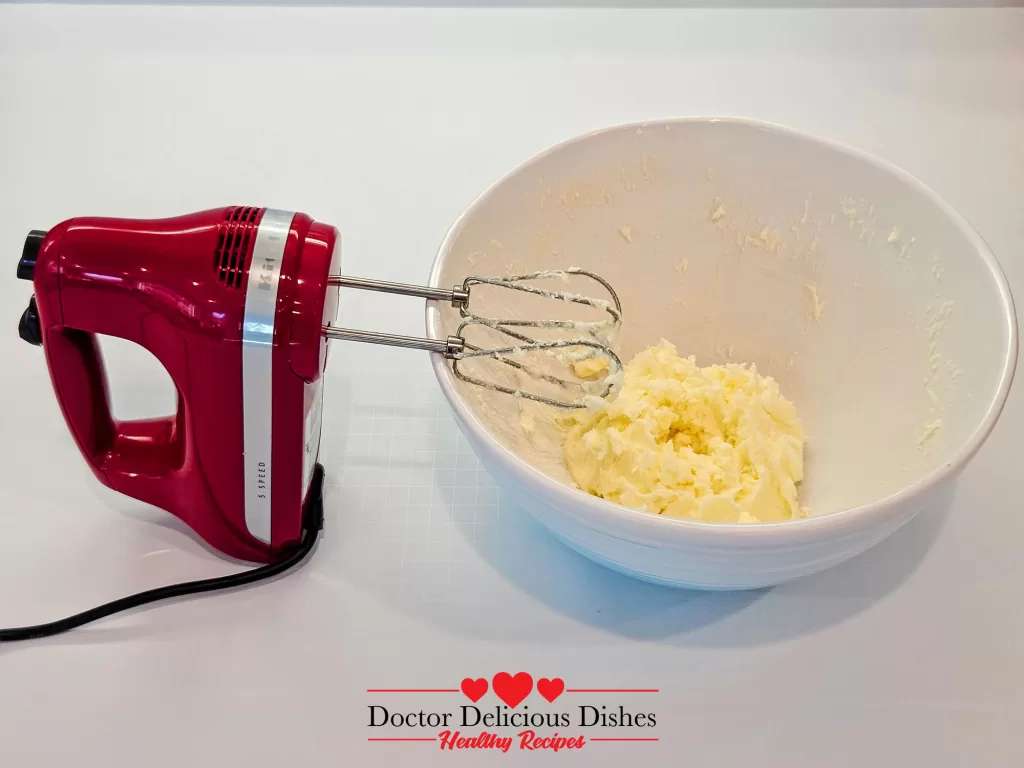 The butter and sugar creamed together in a mixing bowl using the red hand mixer.