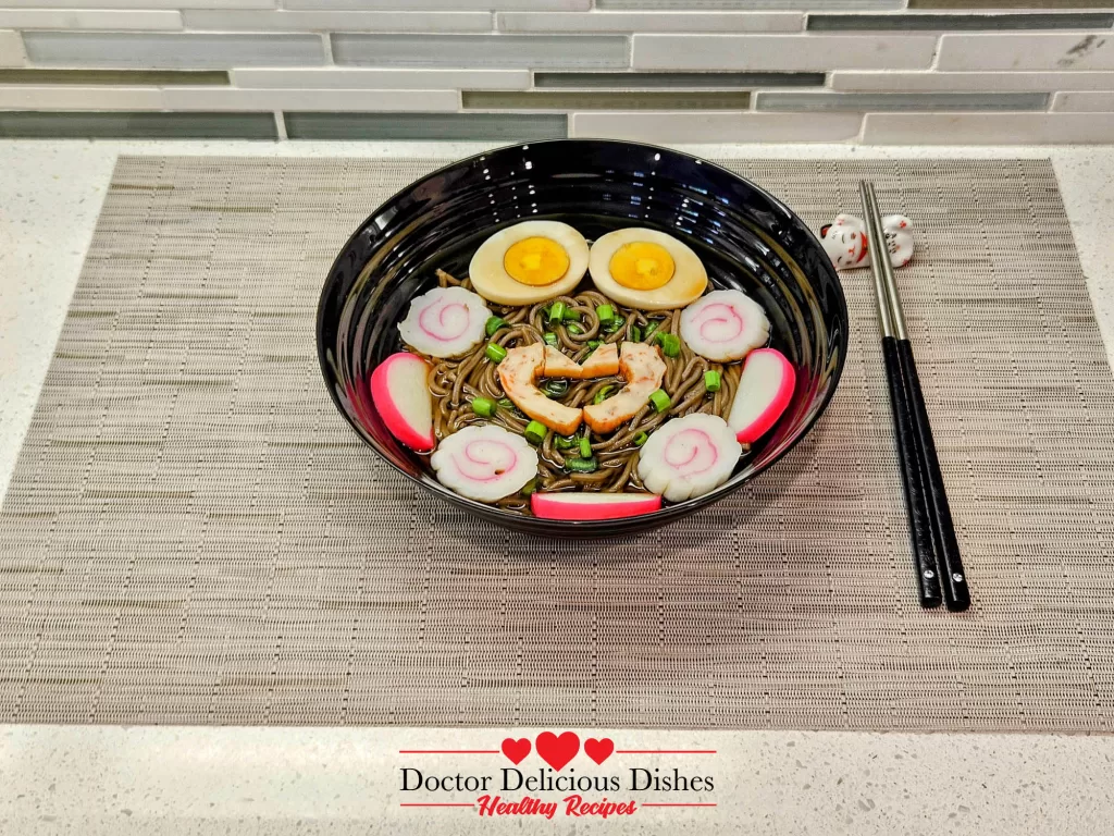 A side-angle view of hot soba noodle soup in a black bowl with chopsticks and a textured woven placemat.