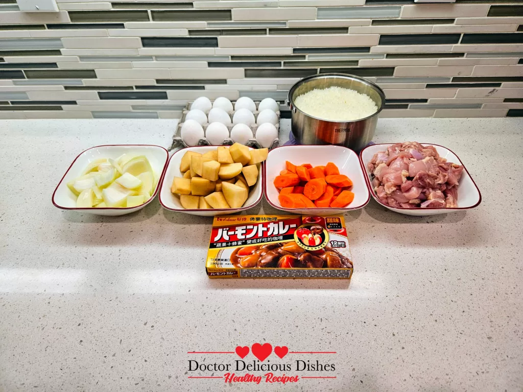 Ingredients prepared and chopped: diced onion, cubed potatoes, sliced carrots, chopped chicken thighs, eggs, and rice, ready to create a flavorful Japanese Chicken Curry Recipe.