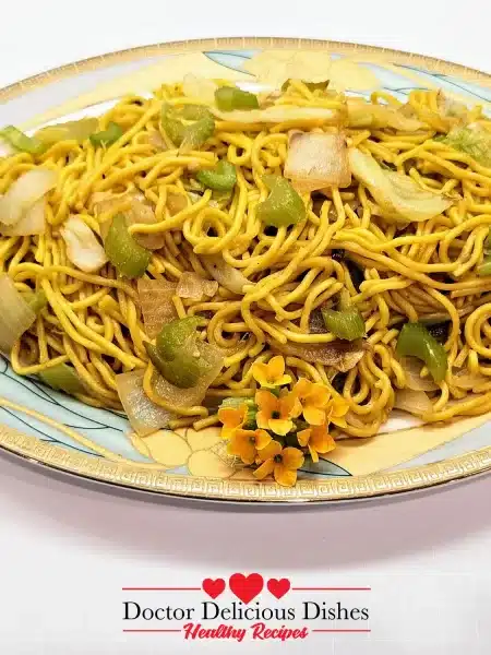 Final plated dish of Copycat Panda Express Chow Mein Noodles, served on a decorative plate, garnished with small orange flowers for presentation.