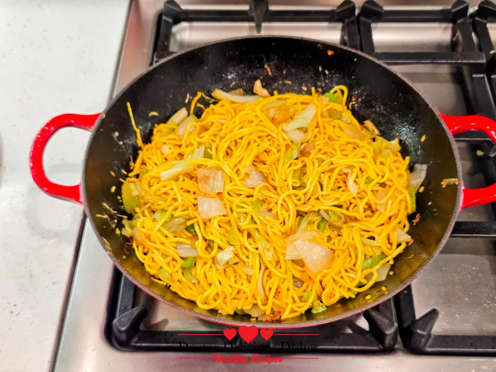 Chow mein noodles stir-fried to perfection, showing a glossy finish and even distribution of vegetables and sauce in the wok.