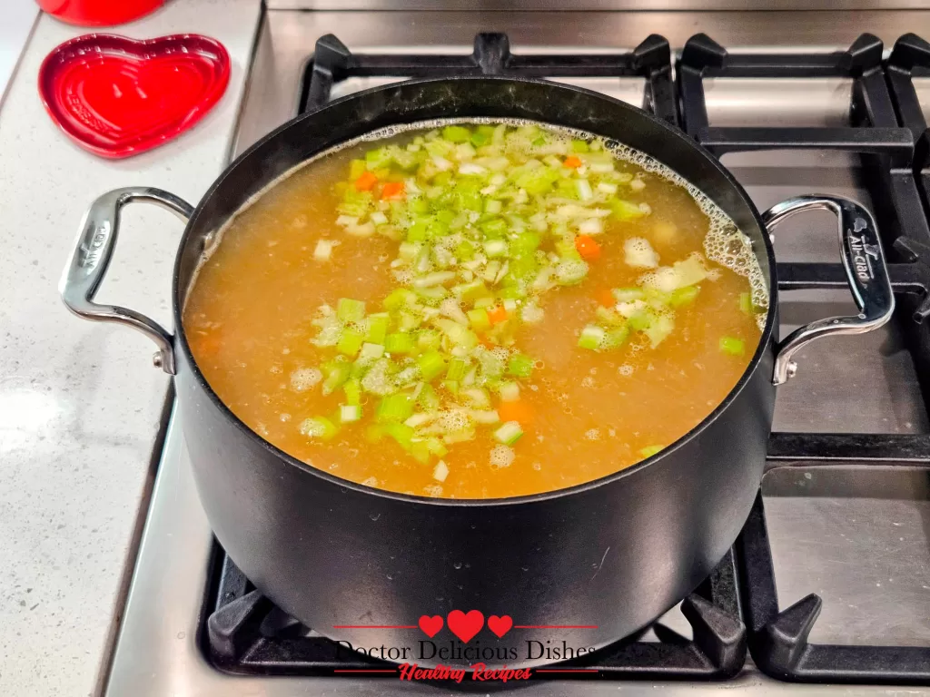 Celery and Carrots cooking in the pot of chicken stock, building flavors for Homemade Chicken Noodle Soup with Egg Noodles.