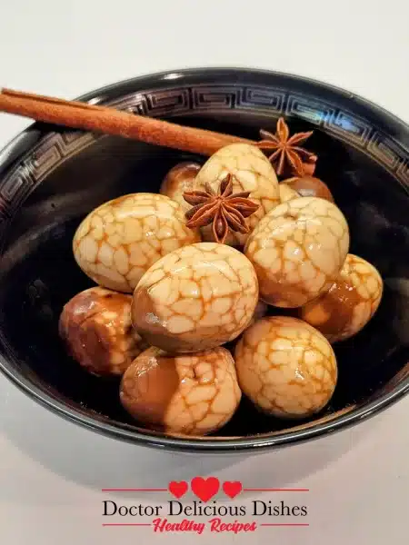 A bowl of Taiwanese-style marbled tea eggs garnished with a cinnamon stick and star anise, ready to serve.
