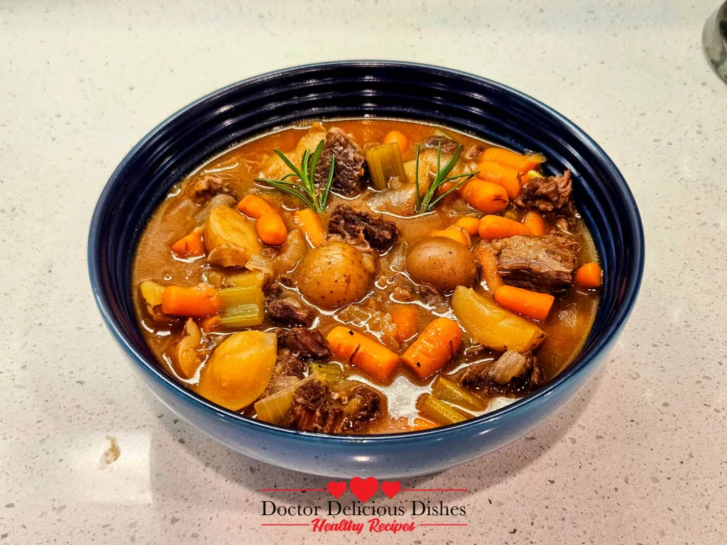 A delicious bowl of Hearty Instant Pot Beef Stew, garnished with fresh rosemary and ready to be enjoyed.