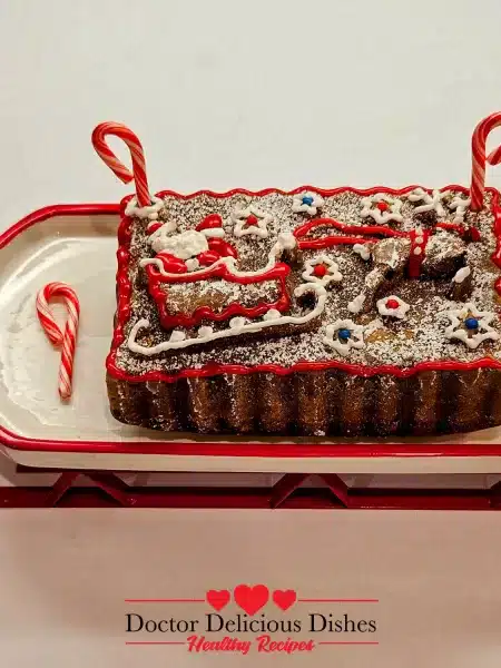 A beautifully decorated Holiday Peppermint Cake served on a festive sled-shaped platter, adorned with icing and candy canes for a charming presentation.