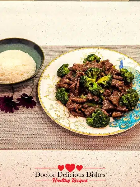 A plated serving of Chinese beef and broccoli with rice, presented on a decorative plate.