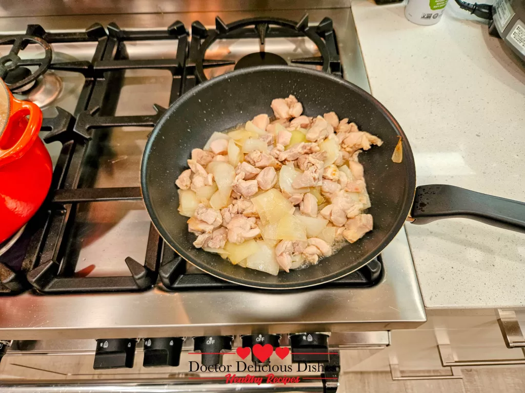 Chicken and onions sautéing in a skillet on the stovetop, building the savory base for the Japanese Chicken Curry Recipe.