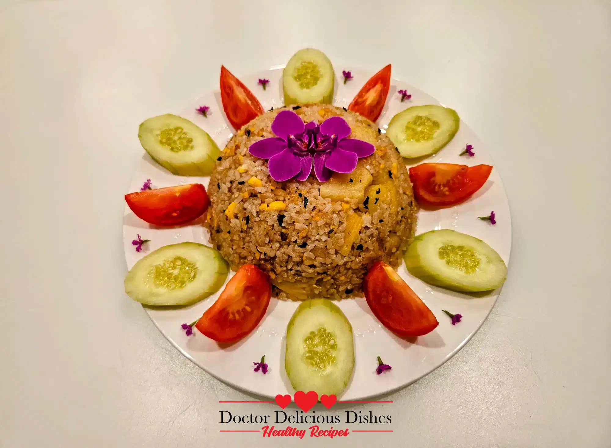 Thai Pineapple Fried Rice beautifully presented with cucumber and tomato slices, garnished with fresh basil and an edible flower.