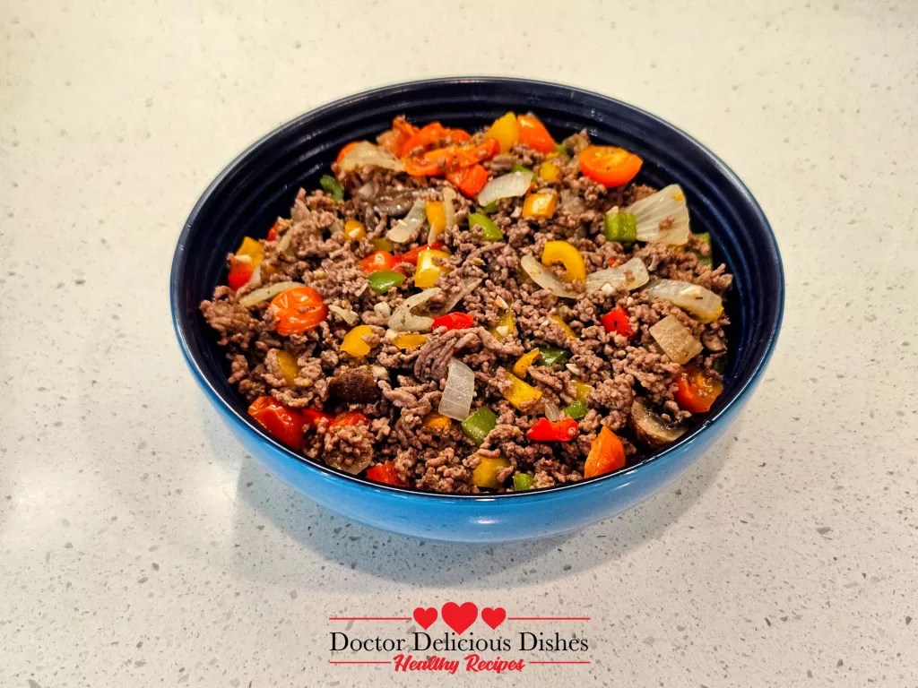 Fully cooked and seasoned ground beef and vegetable mixture in a blue serving bowl, ready to be plated.
