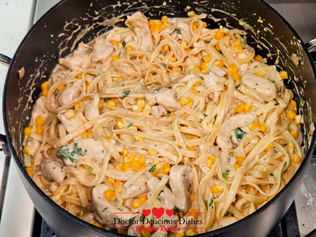 A closer view of pasta, corn, and chicken coated in creamy Alfredo sauce for a Chicken Alfredo Recipe with Jar Sauce.