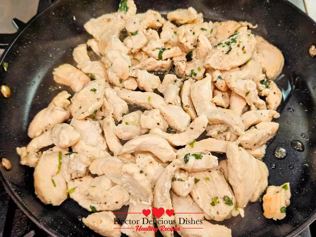 Tender, fully cooked chicken strips in a pan, ready to be combined with Alfredo sauce for a Chicken Alfredo Recipe with Jar Sauce.