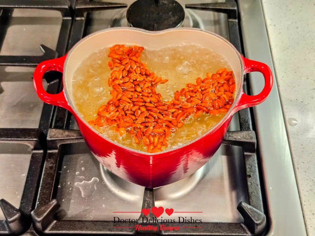 Goji berries added to boiling water in a red Le Creuset pot, the first ingredient for Easy Tong Sui Recipe.