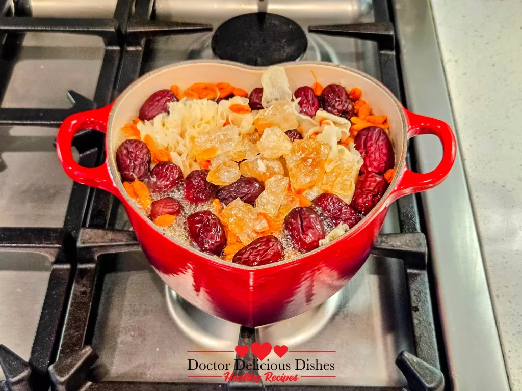 Rock sugar melting into the simmering ingredients inside the Le Creuset pot, balancing flavors in Easy Tong Sui Recipe.