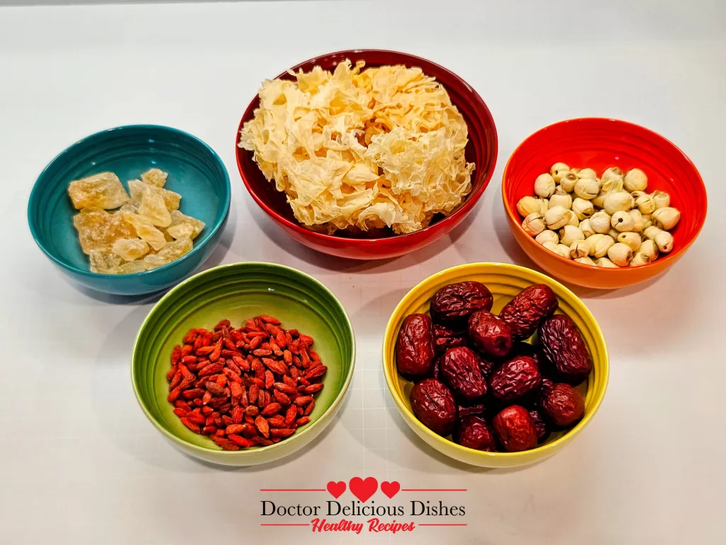 Ingredients for Easy Tong Sui Recipe displayed in colorful Le Creuset bowls, including dried red dates, goji berries, lotus seeds, dried snow fungus, and rock sugar.