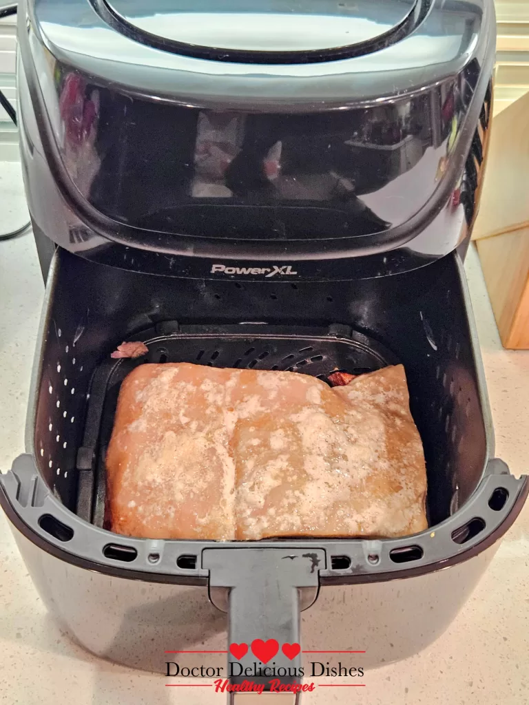 Pork belly placed inside the air fryer basket for final crisping.