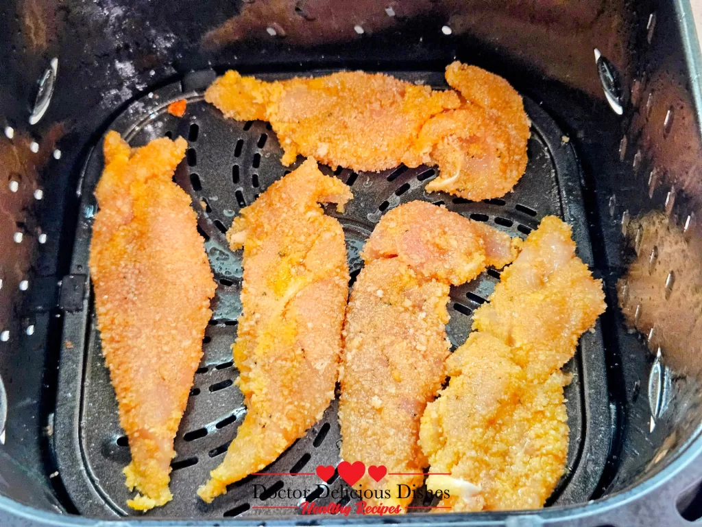 Crispy Air Fryer Chicken Tenders neatly placed in the air fryer basket, ensuring even spacing for best results.