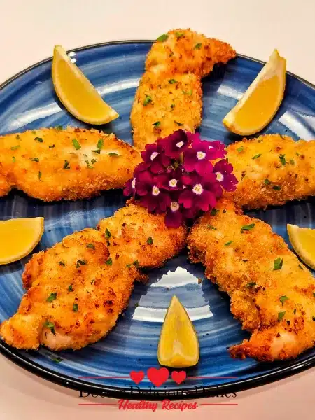 Crispy Air Fryer Chicken Tenders beautifully plated on a blue dish with lemon wedges and garnished with fresh parsley. Part of Air Fryer Recipes.