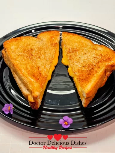 Air fryer grilled cheese plated with small purple and white blossoms.