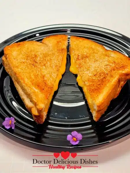 Air fryer grilled cheese plated with small purple and white blossoms.