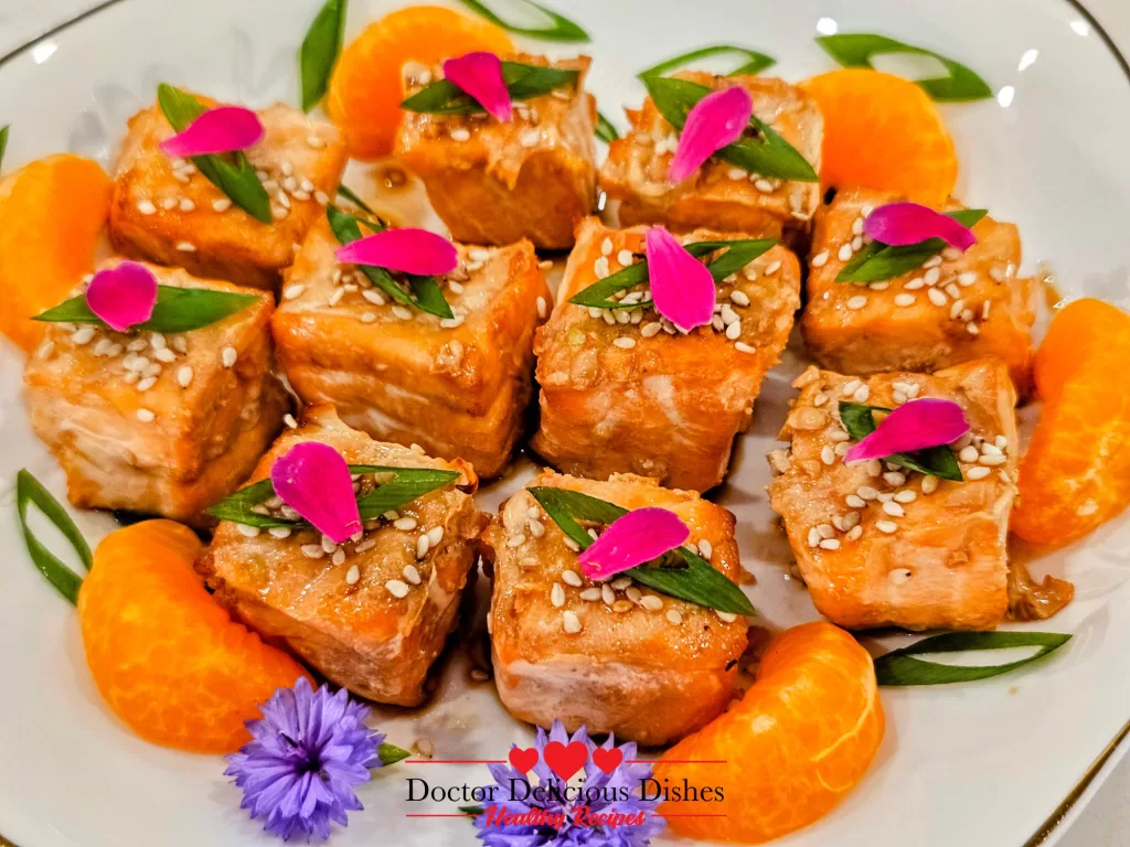 Close-up view of Air Fryer Salmon Bites with sesame seeds and flower petals