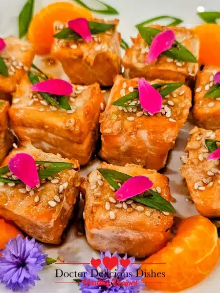 Close-up view of Air Fryer Salmon Bites with sesame seeds and flower petals