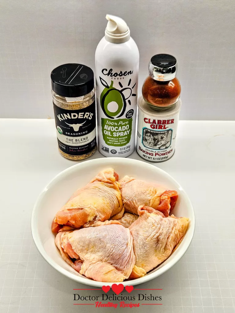 Ingredients for Air Fryer Chicken Thighs including Kinder’s The Blend, avocado oil spray, baking powder, paprika, and raw bone-in chicken thighs.
