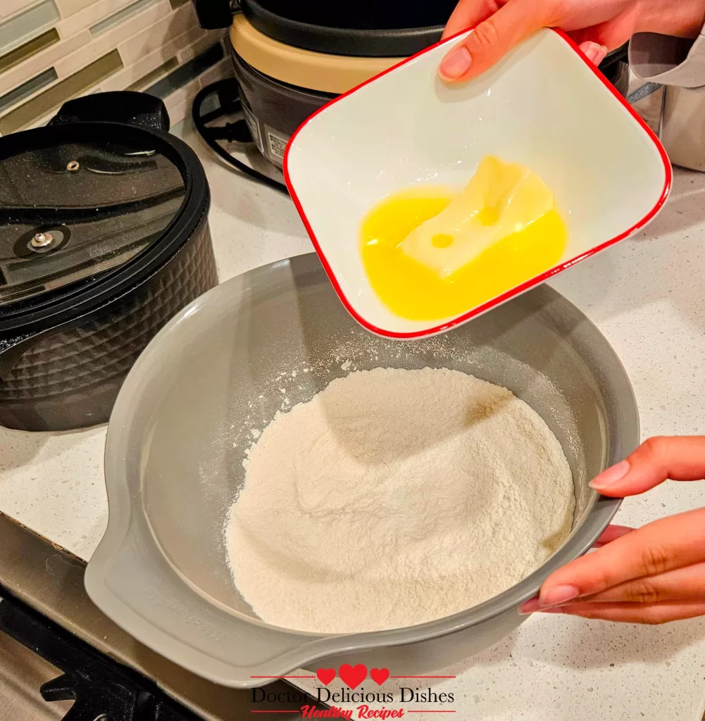 Melted butter poured into flour for apple blueberry crumble recipe topping.