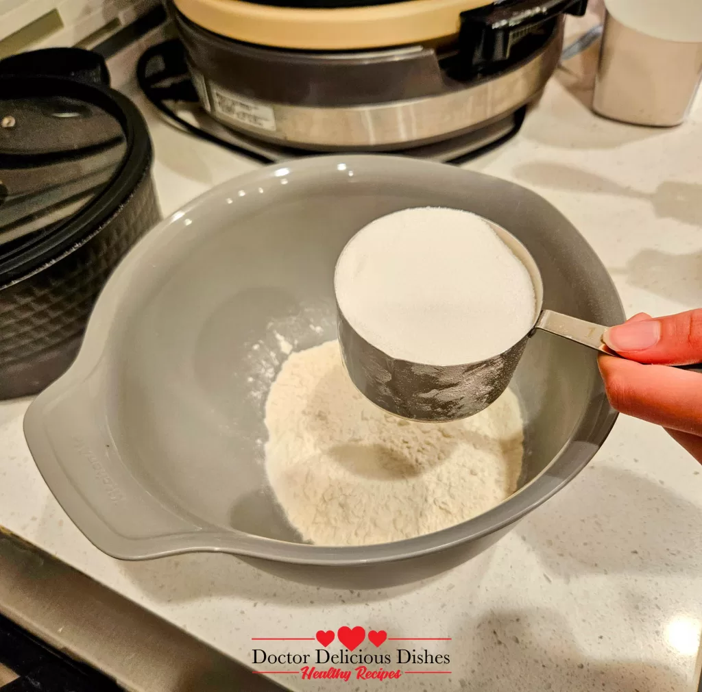 Sugar being added to flour for apple blueberry crumble recipe topping.