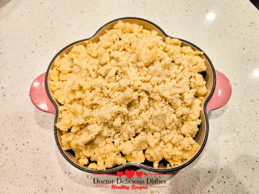 Apple blueberry crumble recipe assembled with topping before baking.