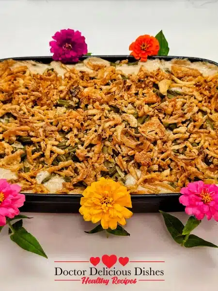 Green bean casserole recipe baked in a dish and decorated with colorful flowers for the holidays.