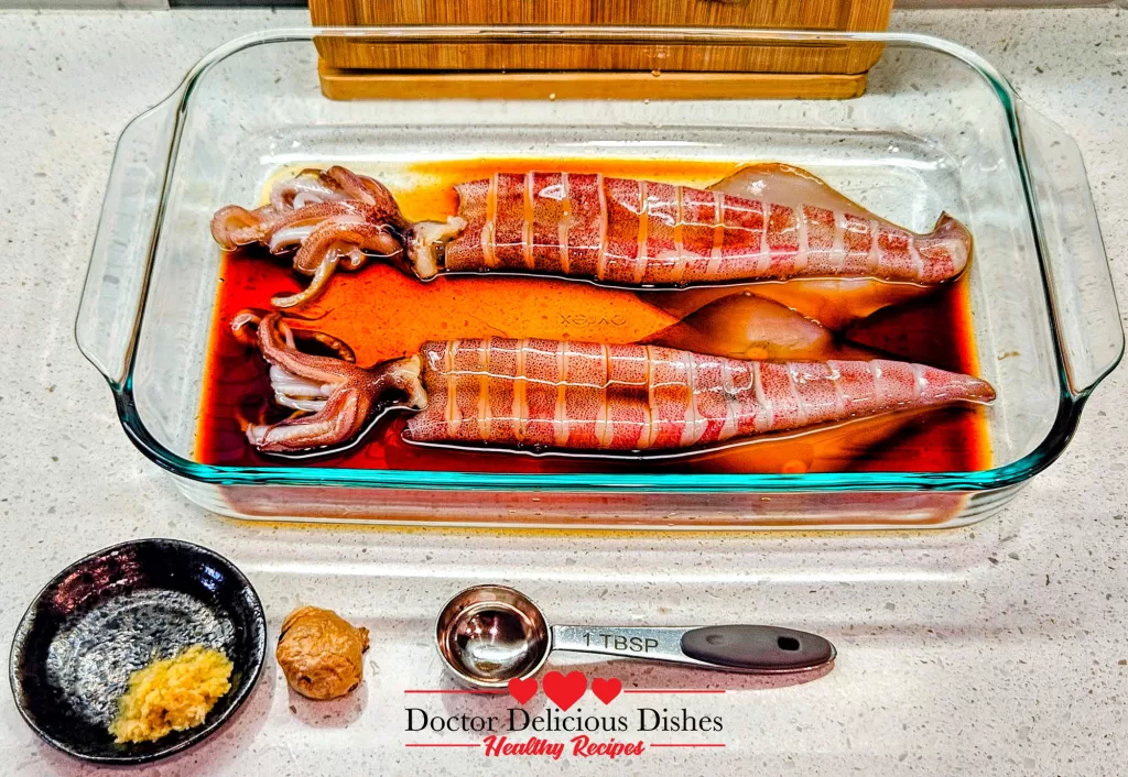 Squid marinating with soy sauce, mirin, sake, and fresh ginger for Japanese grilled squid (Ikayaki).