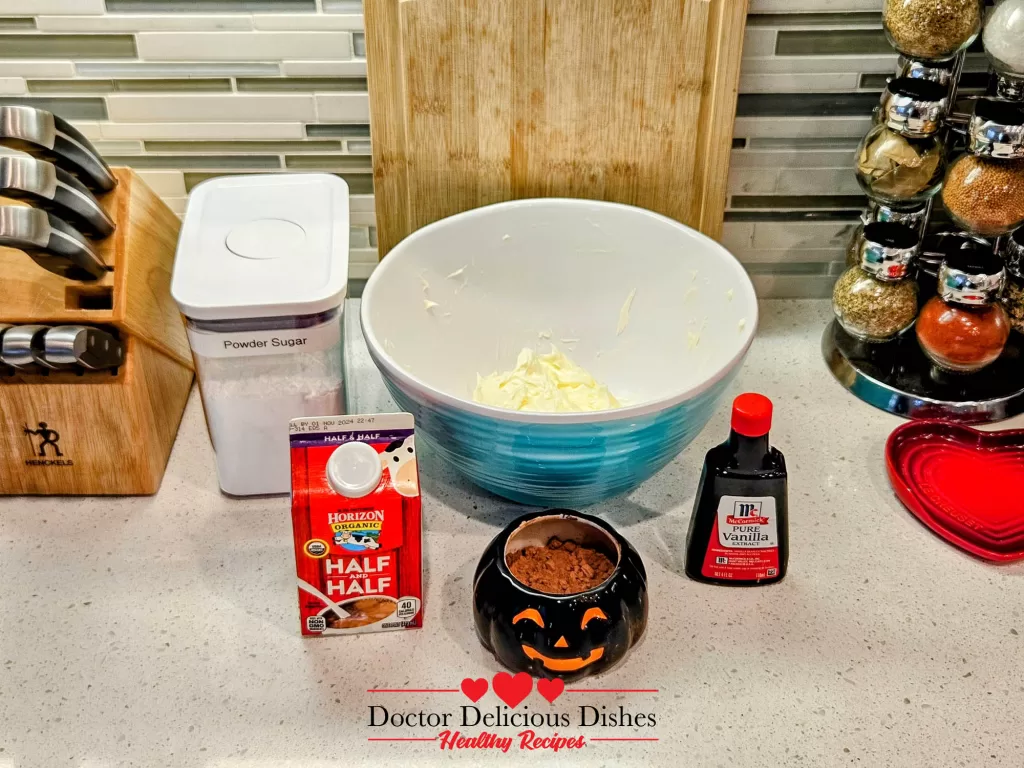 Frosting ingredients including cocoa, sugar, vanilla, and half & half for Halloween cupcakes.