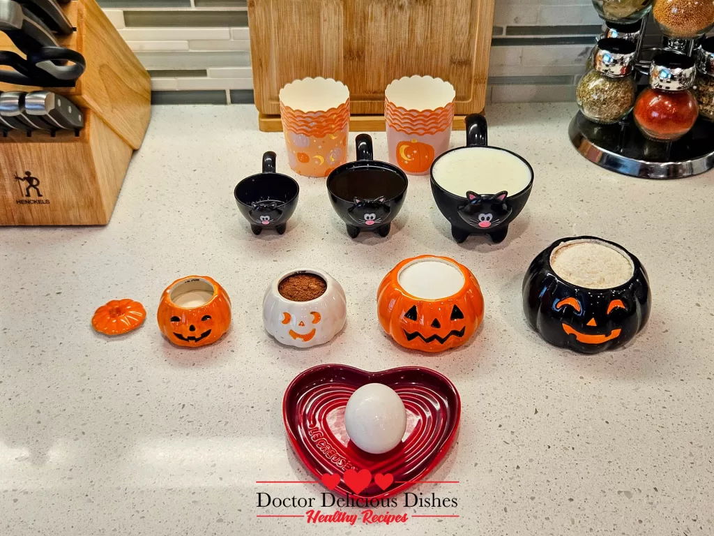 Ingredients measured in Halloween bowls for making chocolate protein Halloween cupcakes.