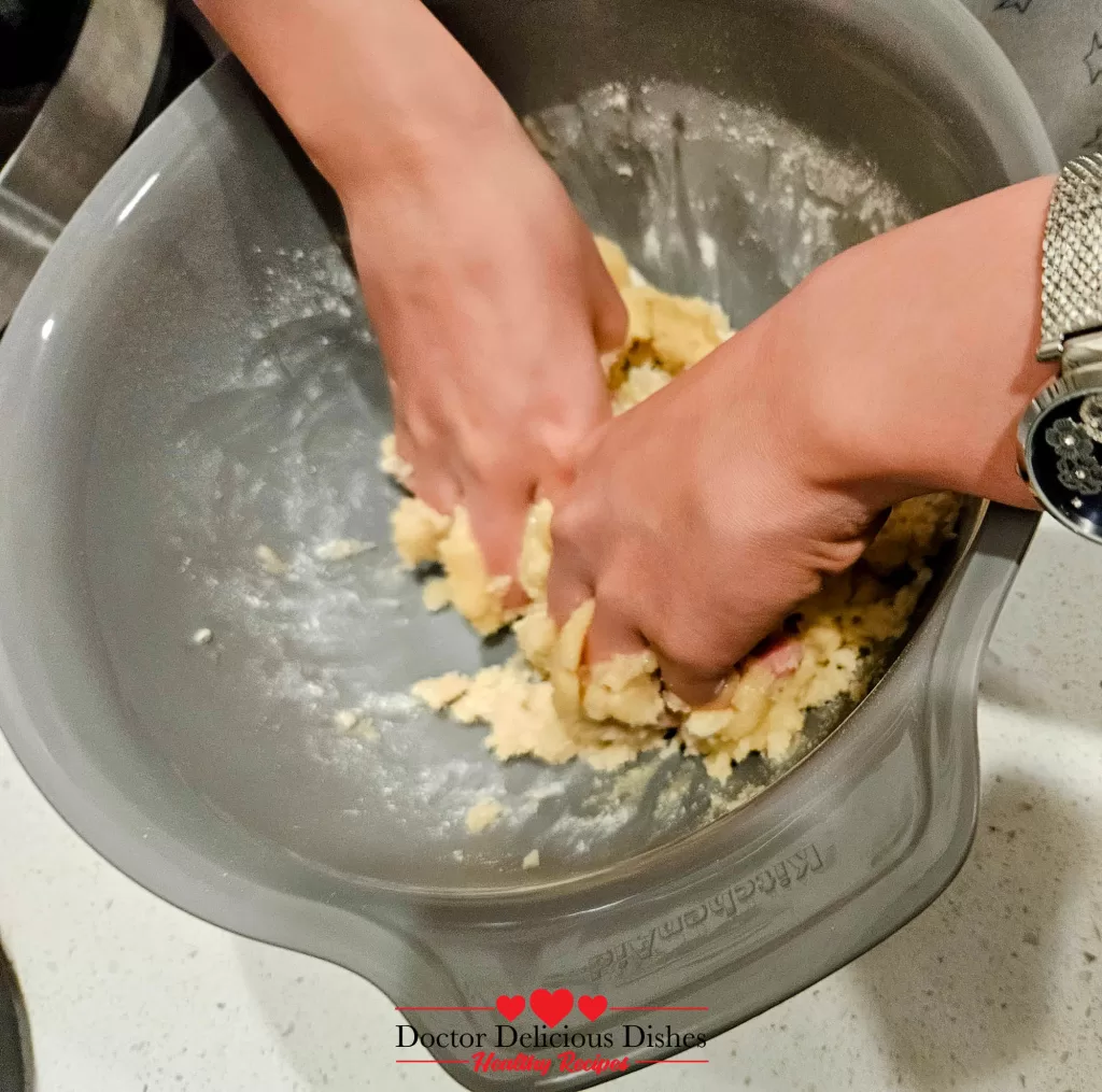 Mixing crumble dough by hand in a bowl for apple blueberry crumble recipe.