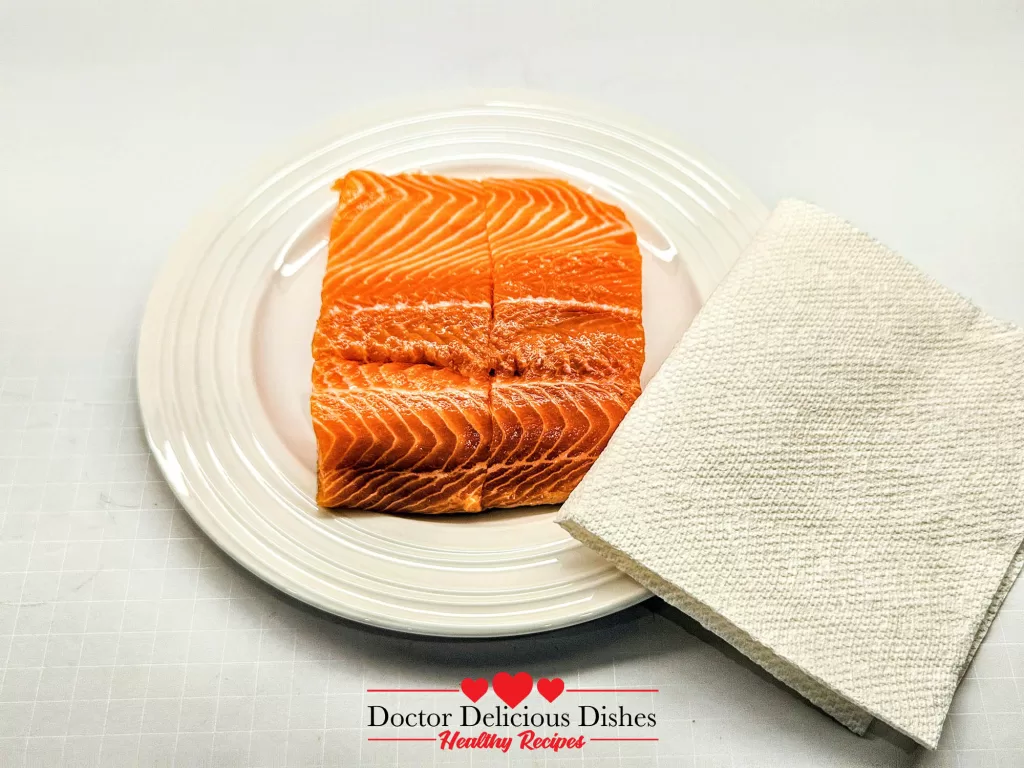 Patting salmon dry with paper towels for extra-crispy Air Fryer Salmon skin.