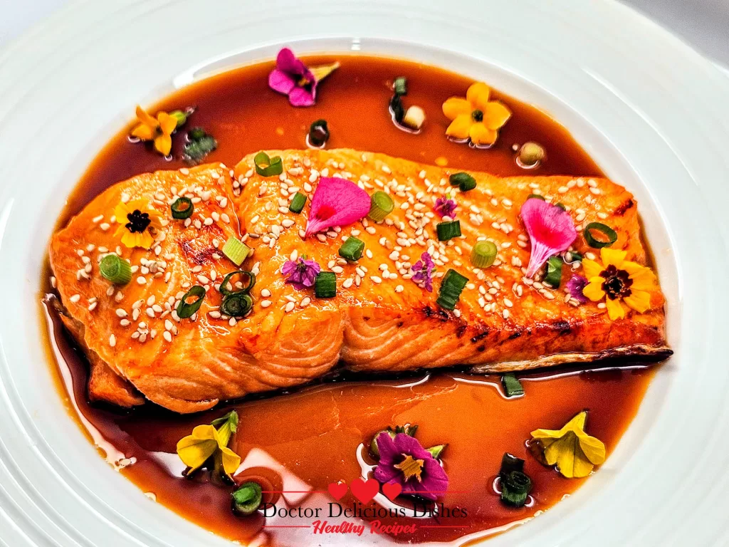 Teriyaki Salmon garnished with sesame seeds and scallions in sauce.