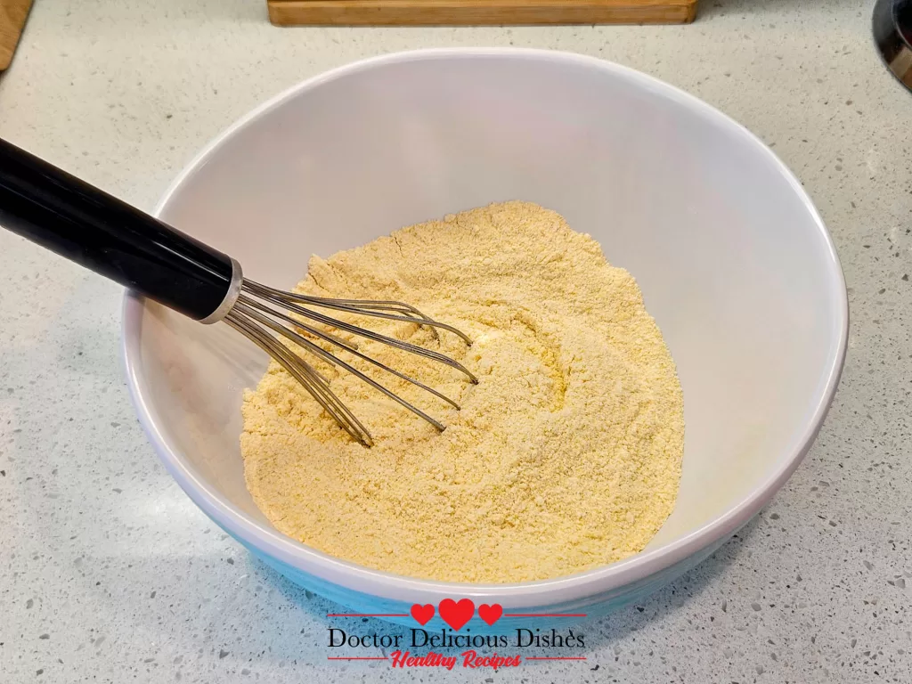 Whisking cornmeal and flour together for Southern cornbread recipe in a mixing bowl