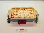 Finished sweet potato casserole recipe with toasted marshmallows styled with flowers.