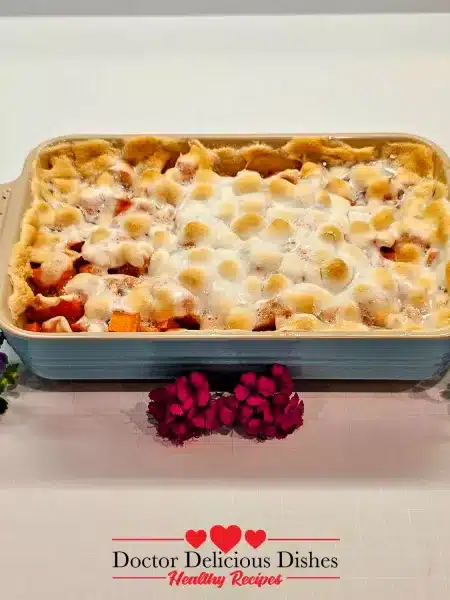 Finished sweet potato casserole recipe with toasted marshmallows styled with flowers.