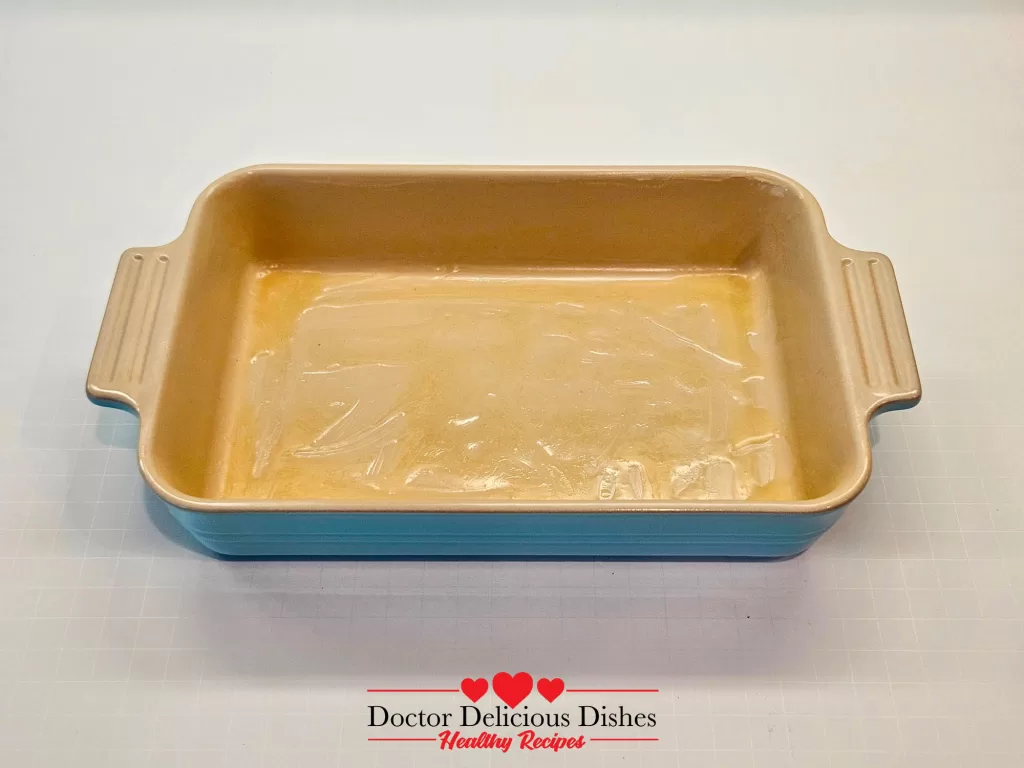 Le Creuset baking dish greased with butter, ready for sweet potato casserole recipe.